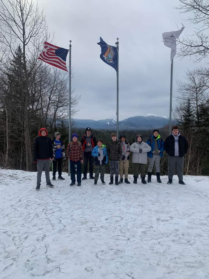 Scouts in Troop 539 in front of flags by ski jumps